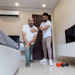 Senior Man Assisted by Caregiver During Home Physiotherapy Session