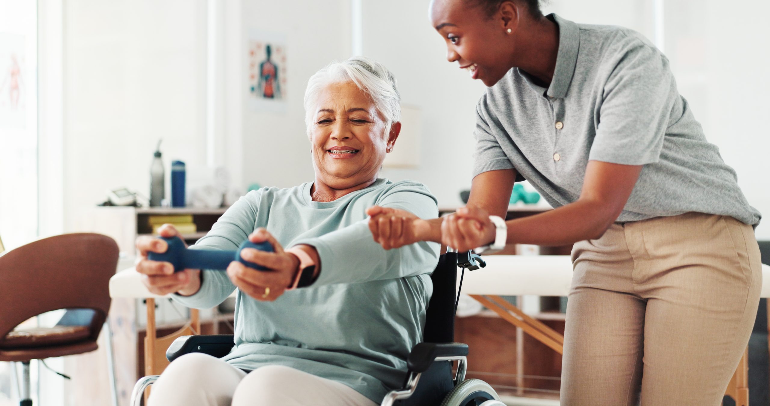 Physiotherapist helping older women with exercises in wheelchair
