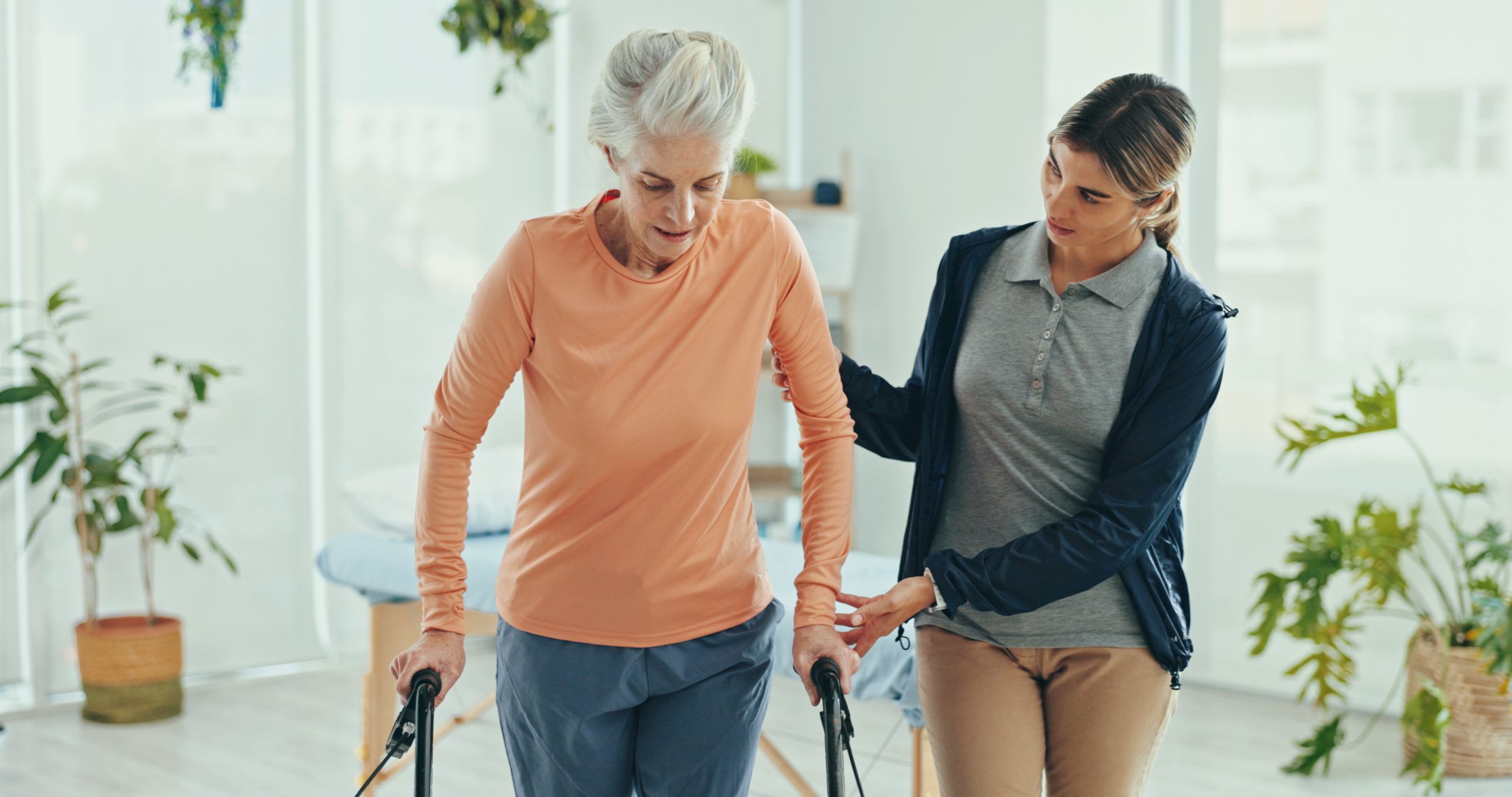 Physiotherapist helping an older client with in-home exercises as part of aged care funding