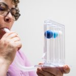 elderly woman doing breathing exercises at home