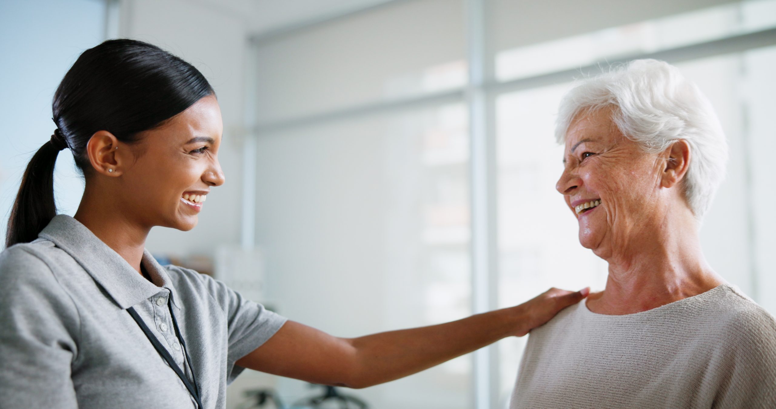 female physiotherapist smiling at elderly woman
