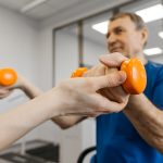 disabled man doing dumbbell exercises with NDIS physiotherapist