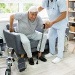 Physiotherapist helping a stroke survivor practise walking at home