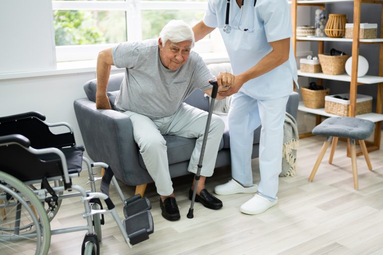 Physiotherapist helping a stroke survivor practise walking at home