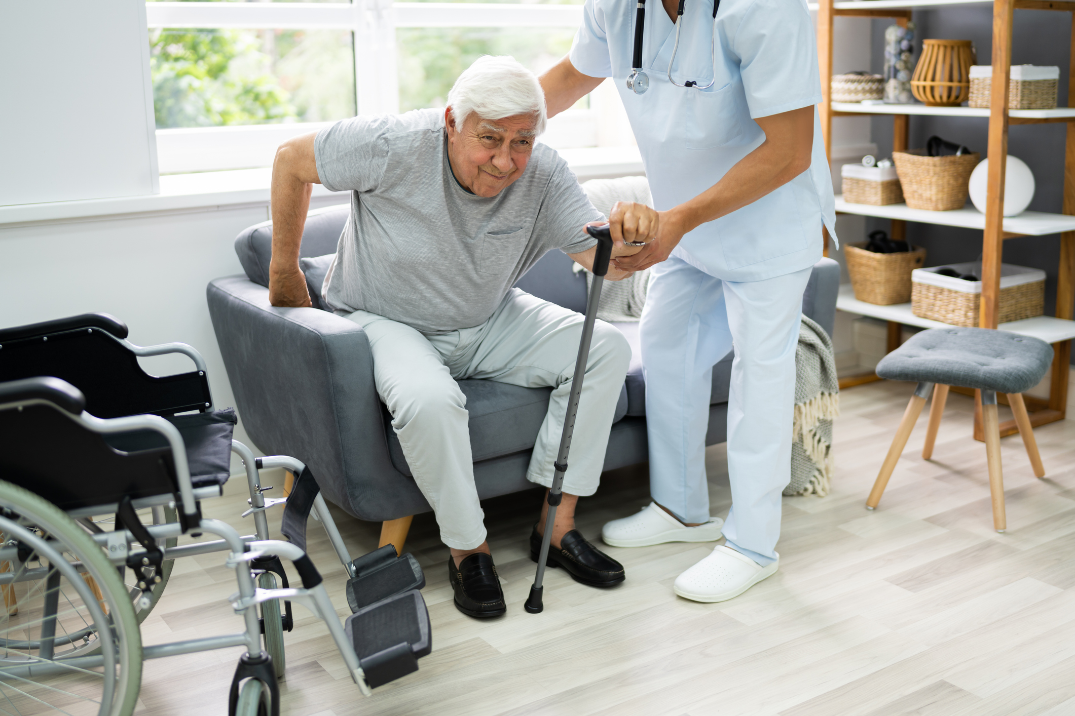 Physiotherapist helping a stroke survivor practise walking at home