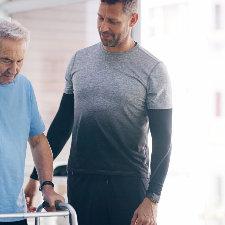 Physiotherapist assisting a man with rollator to walk