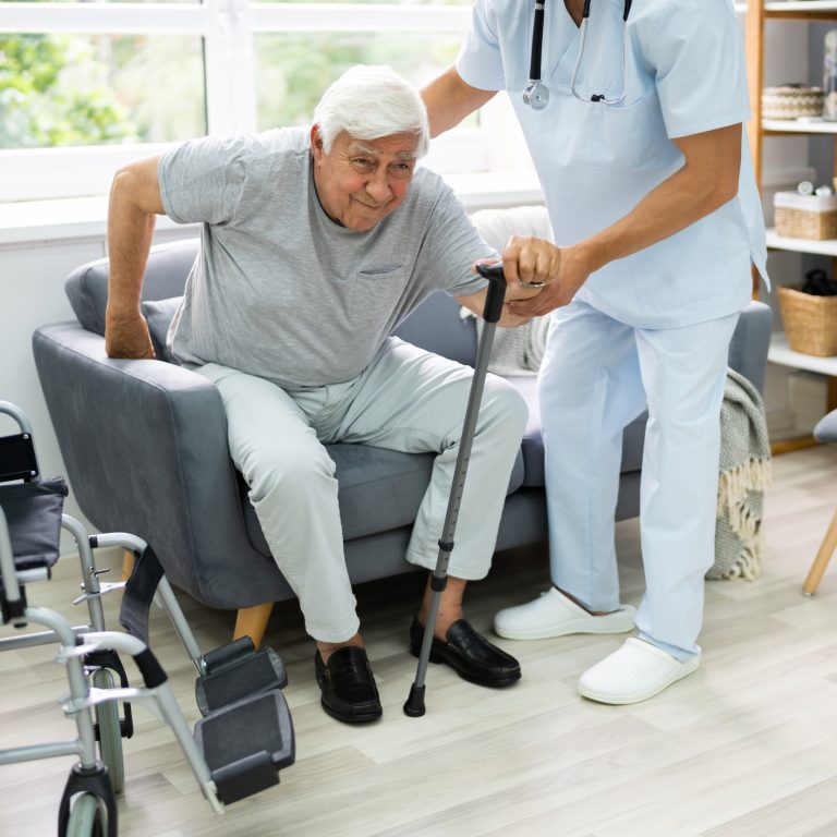 Physiotherapist helping a stroke survivor practise walking at home